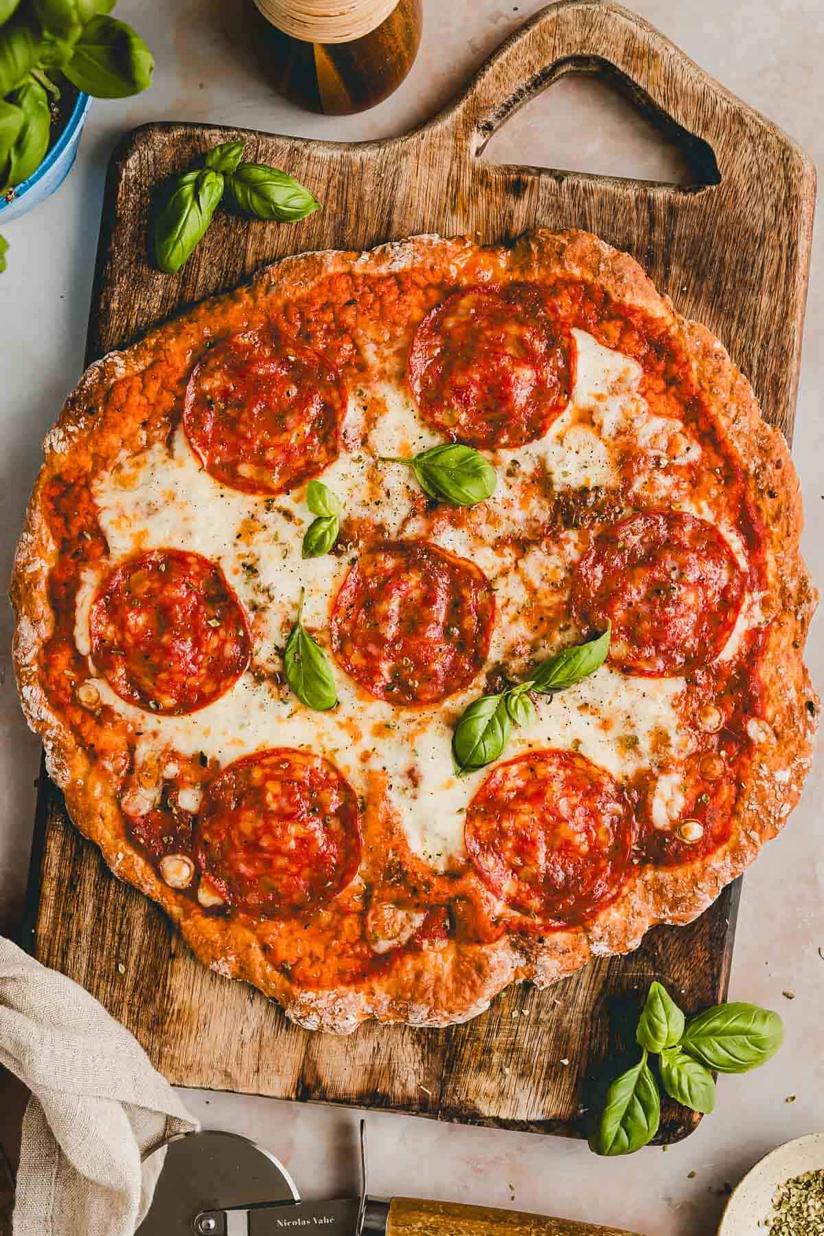 cottage cheese pizza with pepperoni on a wooden board