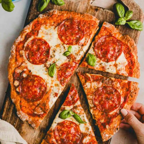 high protein cottage cheese pizza with pepperoni in slices on a wooden board